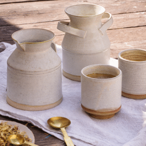 Handmade ceramic morning coffee set with stoneware jug, milk pitcher and cups on rustic table